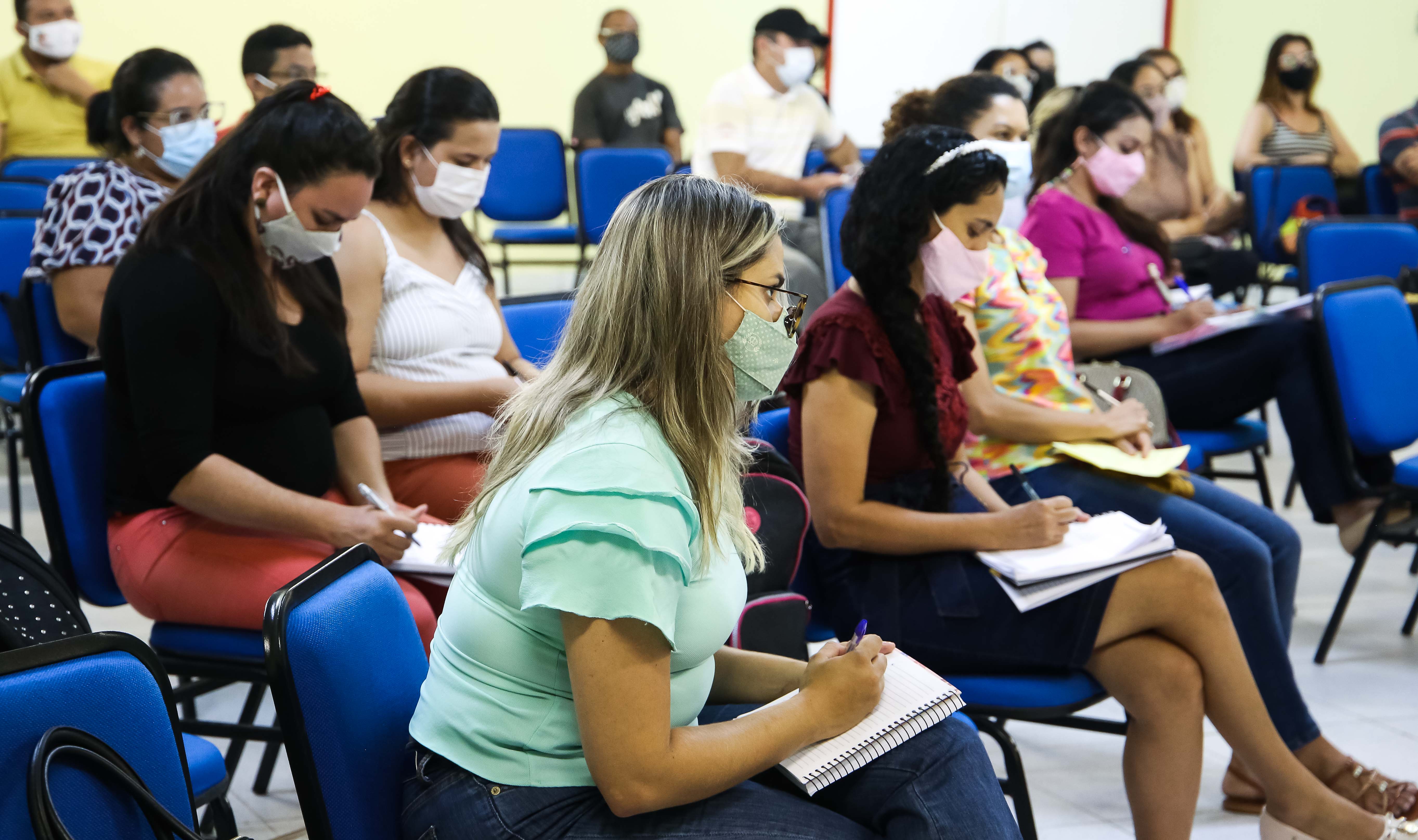 grupo de pessoas de máscara assistindo aula